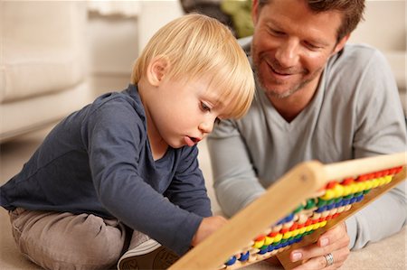 Father and son playing with abacus Foto de stock - Royalty Free Premium, Número: 614-06443003