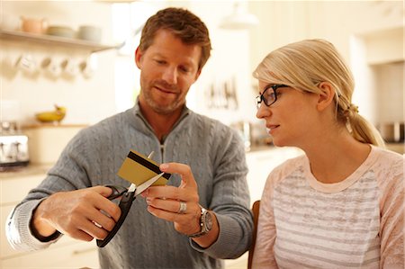 debt - Couple cutting credit card with scissors Stock Photo - Premium Royalty-Free, Code: 614-06443024