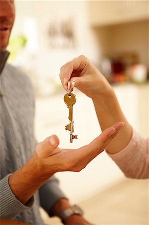 selling home - Woman giving man house key Stock Photo - Premium Royalty-Free, Code: 614-06443027