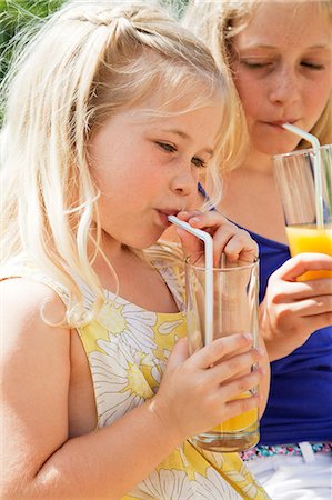 simsearch:614-06443089,k - Two girls drinking orange juice Stock Photo - Premium Royalty-Free, Code: 614-06443084