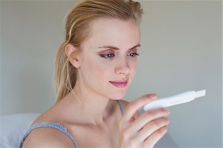 Young woman looking at pregnancy test Stock Photo - Premium Royalty-Free, Code: 614-06443097