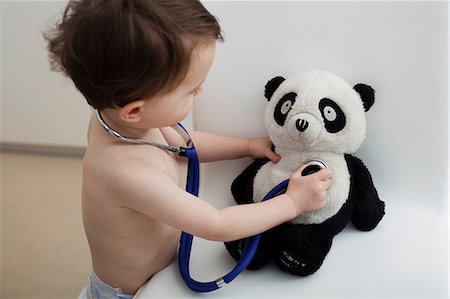 Little boy using stethoscope on panda toy Fotografie stock - Premium Royalty-Free, Codice: 614-06443110