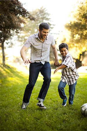 sunshine and looking away and togetherness - Father and son playing soccer together Foto de stock - Sin royalties Premium, Código: 614-06536730