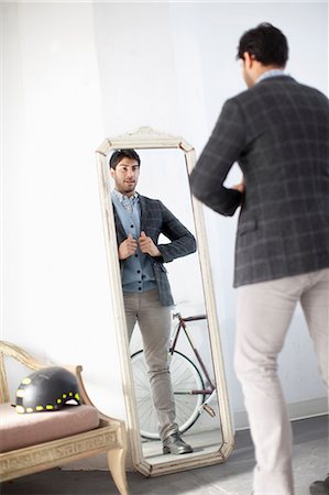 reflection in a mirror - Man examining himself in mirror Stock Photo - Premium Royalty-Free, Code: 614-06536773