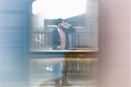 Man on cell phone at train station Stock Photo - Premium Royalty-Free, Code: 614-06536800