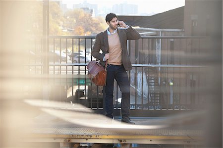 Man on cell phone at train station Stock Photo - Premium Royalty-Free, Code: 614-06536803