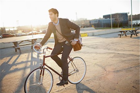 Man riding bicycle on city street Stock Photo - Premium Royalty-Free, Code: 614-06536826