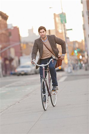 focus (photographic term) - Man riding bicycle on city street Stock Photo - Premium Royalty-Free, Code: 614-06536828