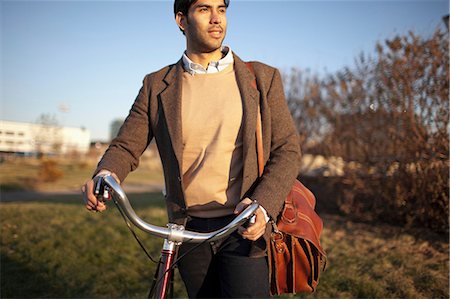 park sun - Man with cell phone pushing bicycle Stock Photo - Premium Royalty-Free, Code: 614-06536821