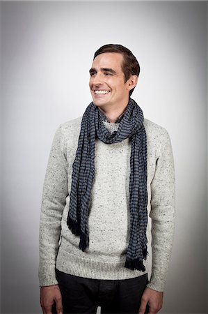 Smiling man wearing scarf indoors Photographie de stock - Premium Libres de Droits, Code: 614-06536867