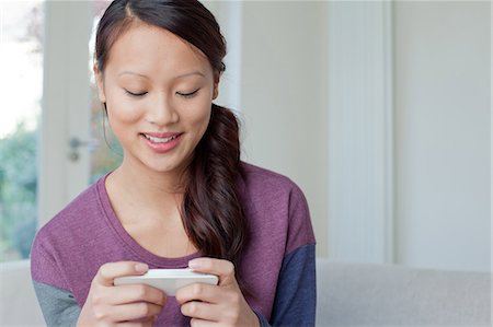 Woman using cell phone on sofa Photographie de stock - Premium Libres de Droits, Code: 614-06536924