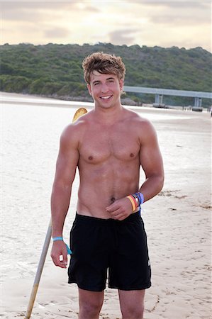 pic of 18 year boy in brown hair - Smiling man standing on beach Stock Photo - Premium Royalty-Free, Code: 614-06537080