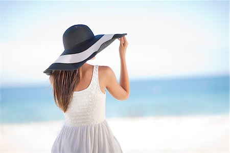 sitting looking at backside - Woman wearing floppy hat on beach Stock Photo - Premium Royalty-Free, Code: 614-06537232