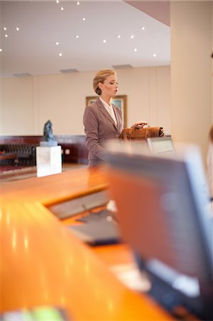 Businesswoman checking into hotel Stock Photo - Premium Royalty-Free, Code: 614-06537247