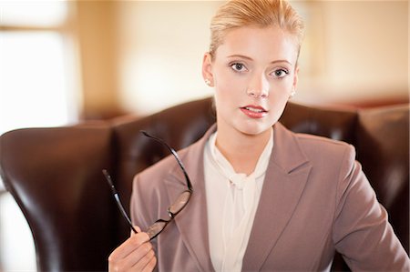 Businesswoman holding glasses at desk Stock Photo - Premium Royalty-Free, Code: 614-06537252