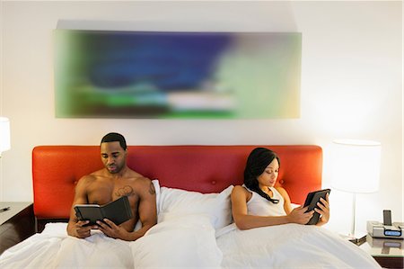 Couple using e-readers in bed Photographie de stock - Premium Libres de Droits, Code: 614-06537446