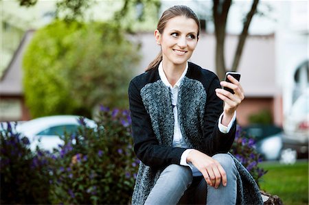 developed land - Woman using cell phone in urban park Stock Photo - Premium Royalty-Free, Code: 614-06537510