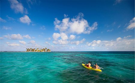 People rowing canoe in tropical water Stock Photo - Premium Royalty-Free, Code: 614-06537524