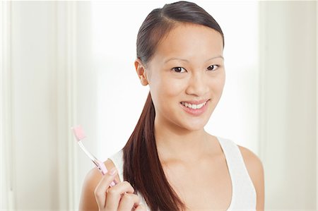 queue-de-cheval - Woman holding toothbrush in bathroom Photographie de stock - Premium Libres de Droits, Code: 614-06537534