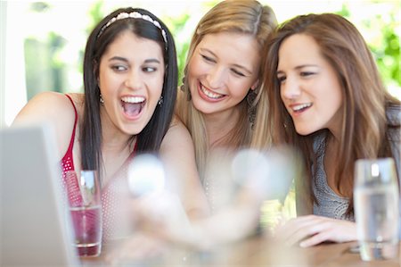 people happy surprise computer - Smiling women using laptop together Stock Photo - Premium Royalty-Free, Code: 614-06537611