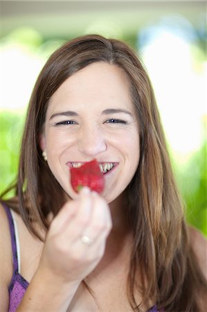 Woman eating fruit outdoors Photographie de stock - Premium Libres de Droits, Code: 614-06537631