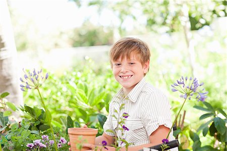 flower garden child - Boy potting plants outdoors Stock Photo - Premium Royalty-Free, Code: 614-06624057