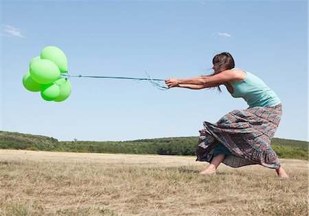 Woman carrying bunch of balloons Stock Photo - Premium Royalty-Free, Code: 614-06624155