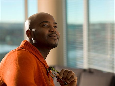 pic of a man dreaming - Man holding eyeglasses in living room Stock Photo - Premium Royalty-Free, Code: 614-06624240