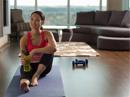 exercising indoors one - Woman resting on yoga mat in living room Stock Photo - Premium Royalty-Free, Code: 614-06624262