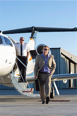 Businessman on airplane runway Stock Photo - Premium Royalty-Free, Code: 614-06624357