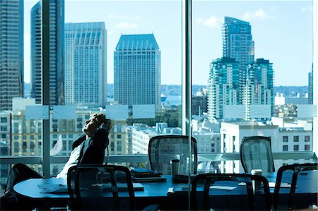 people at work conference room windows - Businessman relaxing at desk in office Stock Photo - Premium Royalty-Free, Code: 614-06624436