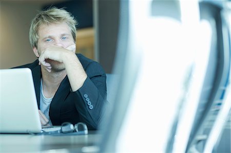 Businessman using laptop at desk Stock Photo - Premium Royalty-Free, Code: 614-06624437