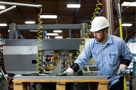 Worker examining product in metal plant Photographie de stock - Premium Libres de Droits, Code: 614-06624529