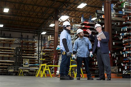 Workers and businessman in metal plant Stock Photo - Premium Royalty-Free, Code: 614-06624536