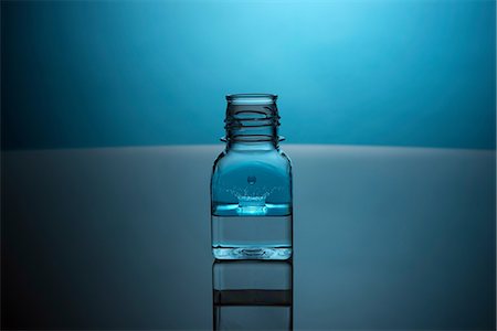 simsearch:614-06624533,k - Drop splashing in glass bottle Foto de stock - Sin royalties Premium, Código: 614-06624614
