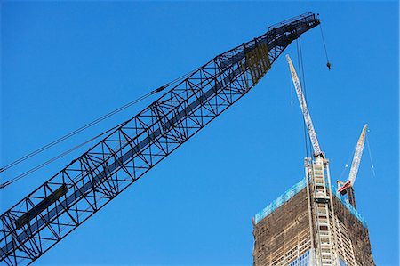 Low angle view of crane and skyscraper Photographie de stock - Premium Libres de Droits, Code: 614-06624705