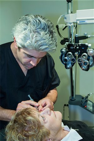 face to face shot photo - Doctor giving patient eye injection Stock Photo - Premium Royalty-Free, Code: 614-06624811