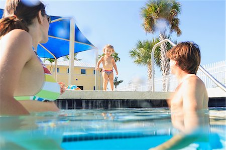 standing sunglasses man 40s - Toddler running to parents in pool Stock Photo - Premium Royalty-Free, Code: 614-06624885