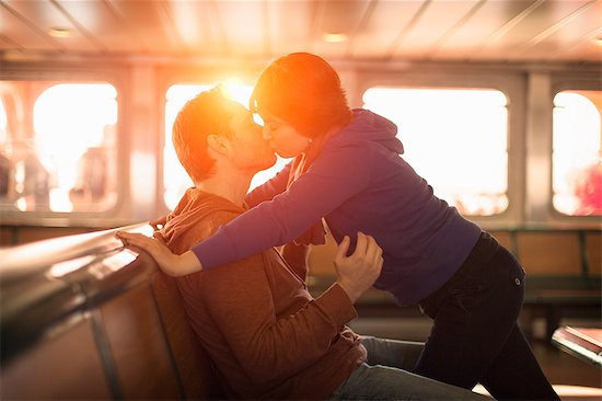 Couple kissing on ferry at sunset Stock Photo - Premium Royalty-Free, Image code: 614-06625000