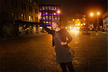 people in the city at night - Woman hailing taxi on city street Stock Photo - Premium Royalty-Free, Code: 614-06625026