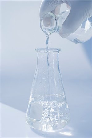 simsearch:614-07652263,k - Scientist pouring liquid into beaker Foto de stock - Sin royalties Premium, Código: 614-06625114