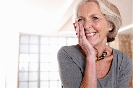 senior woman indoor portraits - Smiling older woman gasping Stock Photo - Premium Royalty-Free, Code: 614-06625159