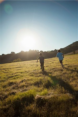 fun run - Boys running in grassy field Stock Photo - Premium Royalty-Free, Code: 614-06625239