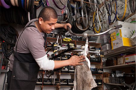Mechanic working in bicycle shop Stock Photo - Premium Royalty-Free, Code: 614-06625230