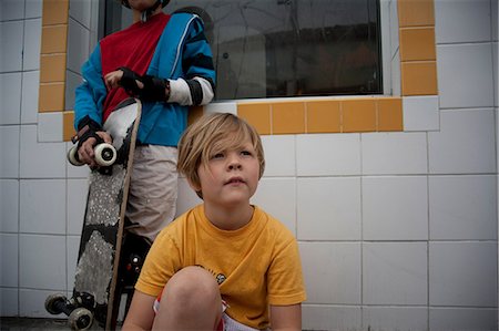 portrait of boy sitting on skateboard - Boys with skateboard sitting outdoors Stock Photo - Premium Royalty-Free, Code: 614-06625245