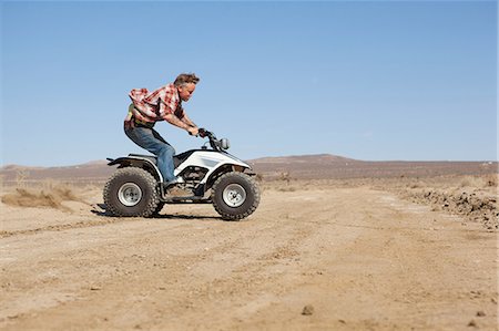 full length side view standing - Man riding four-wheeler in desert Stock Photo - Premium Royalty-Free, Code: 614-06625240