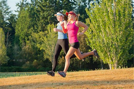 Teenage girls running together in field Foto de stock - Sin royalties Premium, Código: 614-06625276