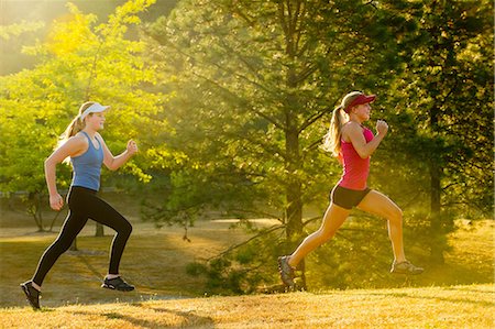 female runner side view - Teenage girls running together in field Stock Photo - Premium Royalty-Free, Code: 614-06625279