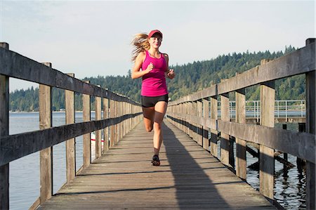 Teenage girl running on wooden dock Foto de stock - Sin royalties Premium, Código: 614-06625286