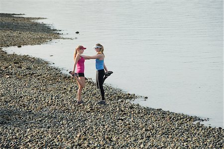 Teenage girls stretching on rocky beach Foto de stock - Sin royalties Premium, Código: 614-06625289